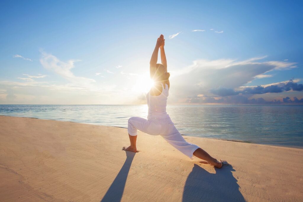 woman doing yoga on beach